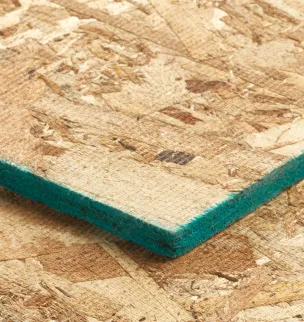 Close-up of a wooden chipboard panel with a green edge, resting on another identical panel.